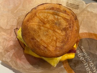McGriddle (zwei Pancakes mit eingebackenem Ahornsirup, dazwischen Rührei, eine Scheibe Käse und Bacon)